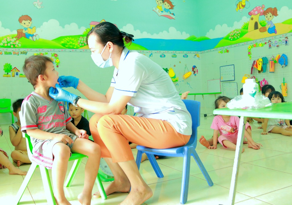 Cán bộ Trạm Y tế xã Bù Nho cho trẻ uống thuốc giun tại trường mẫu giáo Bù Nho.